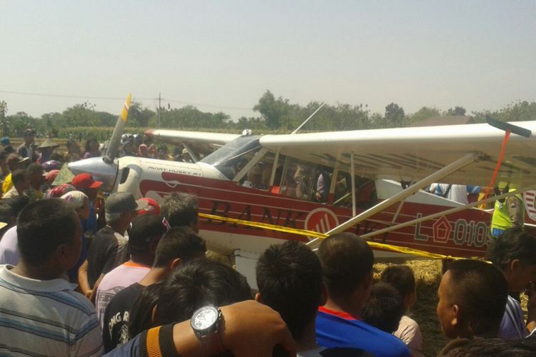 Pesawat penumpang type Aviat Husky milik KONI DKI Jakarta menjadi tontonan warga setelah mendarat  darurat di area persawahan Desa Carangrejo, Kecamatan Sampung, Kabupaten Ponorogo, Jawa Timur, Minggu ( 13/8/2017) siang. 