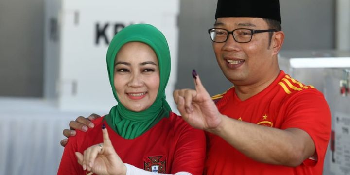 Ridwan Kamil bersama istrinya, Atalia Praratya usai melakukan pencoblosan di TPS 21, Cigadung, Kota Bandung, Rabu (27/6/2018).