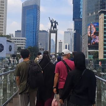Momen libur Lebaran dimanfaatkan masyarakat untuk berwisata di Ibu Kota. Salah satu lokasi yang ramai dikunjungi yakni anjungan halte TransJakarta yang dipadati pengunjung pada Minggu (22/3/2026). 