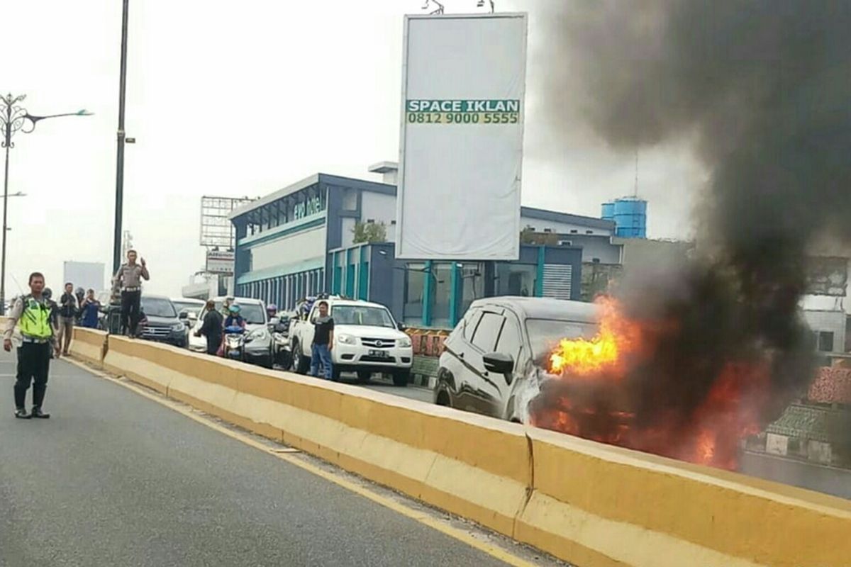 Kebakaran mobil Mitsubishi Expander di atas fly over Jalan Jenderal Sudirman, Kota Pekanbaru, Riau, Sabtu (31/8/2019).