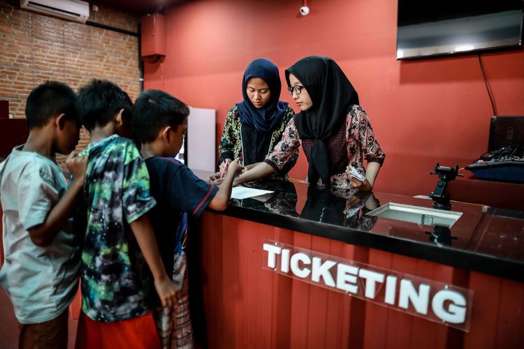 Anak-anak antri membeli tiket untuk menonton bioskop di Pasar Teluk Gong, Penjaringan, Jakarta Utara, Jumat (5/7/2019). Perumda Pasar Jaya bekerja sama dengan Persatuan Artis Film Indonesia membangun bioskop rakyat bernama Indiskop atau Bioskop Independen dengan fasilitas dua studio yang berkapasitas masing-masing 128 kursi penonton untuk masyarakat berpenghasilan menengah ke bawah untuk ruang belajar produksi film serta mengajak masyarakat agar gemar menonton film Indonesia.