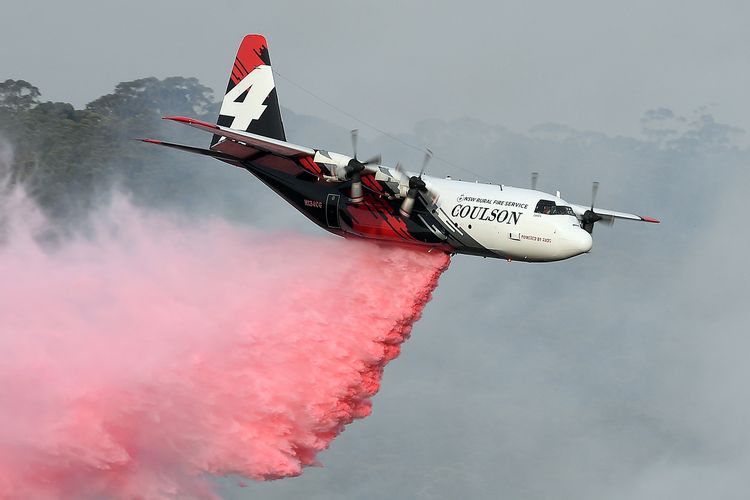 Foto yang diambil pada 10 Januari 2020 menunjukkan pesawat Hercules C-130 menyemprotkan air ke sebuah operasi di New South Wales dalam kebakaran hutan. 3 orang anggota pemadam kebakaran asal AS tewas ketika pesawat Hercules yang mereka naiki untuk memadamkan api jatuh.