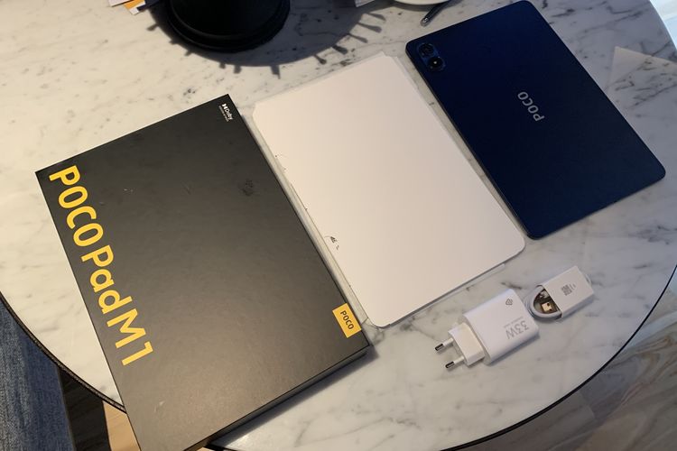 Isi boks kemasan Poco Pad M1, yang terdiri dari satu unit tablet, buku panduan, kabel USB C, dan adaptor pengisian daya 33 watt.
