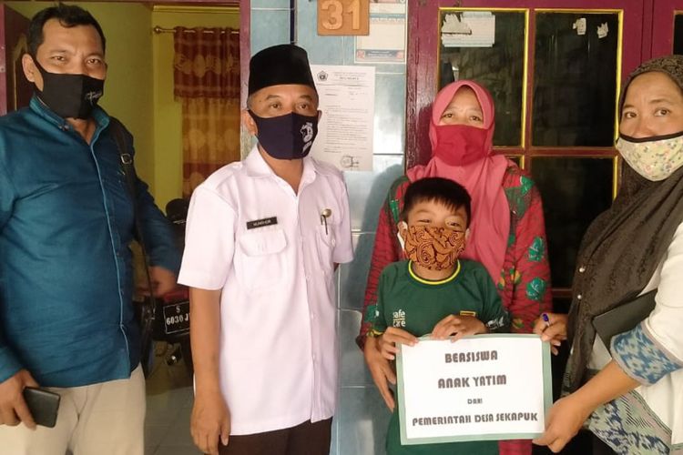 Rafa Ibrahim dan ibunya (tengah), saat menerima bantuan biaya pendidikan gratis dari Pemdes Sekapuk.