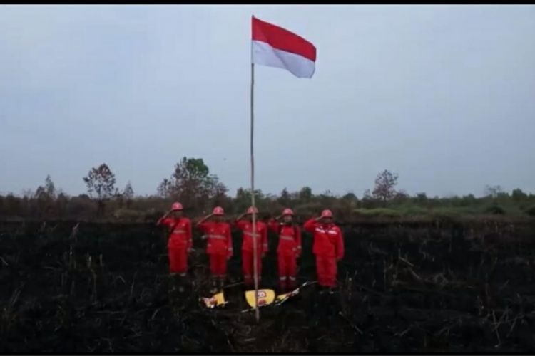 Tim satgas karhutla dari manggala agni daops pekanbaru melaksanakan upacara hut ri ke-73 di lahan sisa kebakaran lahan di desa karya indah kabupaten kampar riau