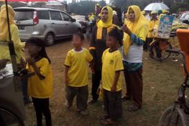 Simpatisan Partai Golkar membawa anak di bawah umur saat kampanye terbuka di Lapangan Multiguna, Bekasi, Senin (17/3/2014).
