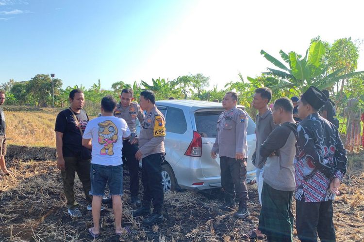 Pihak kepolisian mendatangi mobil yang terperosok di area persawahan di sebelah Waduk Desa Rancangkencono, Kecamatan/Kabupaten Lamongan, Jawa Timur, Rabu (31/7/2024).