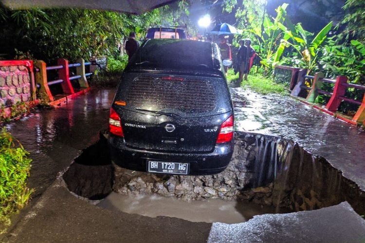 Satu unit mobil terperosok ke lubang jalan ambrol dekat jembatan penghubung antara Desa Cepokosawit dan Desa Jenengan di Kecamatan Sawit, Kabupaten Boyolali, Jawa Tengah, Kamis (16/2/2023) malam.