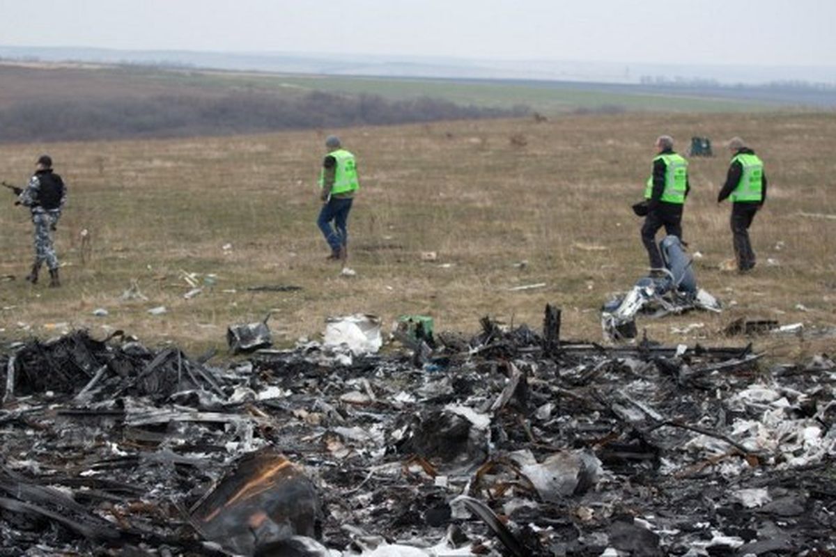 Dalam foto yang diambil pada 11 November 2014 ini, penyelidik Belanda didampingi oleh pemberontak bersenjata pro-Rusia tiba di dekat puing-puing Malaysia Airlines MH17, di lokasi kecelakaan dekat desa Grabove, timur Ukraina. MH17 jatuh menewaskan 298 orang di wilayah terpencil yang dikuasai pemberontak di timur Donetsk.