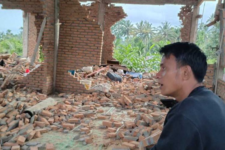Suardi (33) melihat rumahnya yang roboh akibat gempa bumi di Siparayo, Kecamatan Tigo Nagari, Kabupaten Pasaman, Sumatera Barat, Minggu (27/2/2022).