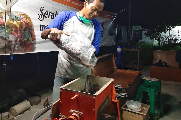 Proses memasukan sampah plastik kresek yang sudah dipotong-potong kecil kedalam mesin cetakan. plastik ini akan dicampur pasir dan dipanaskan untuk menghasilkan produk bangunan.