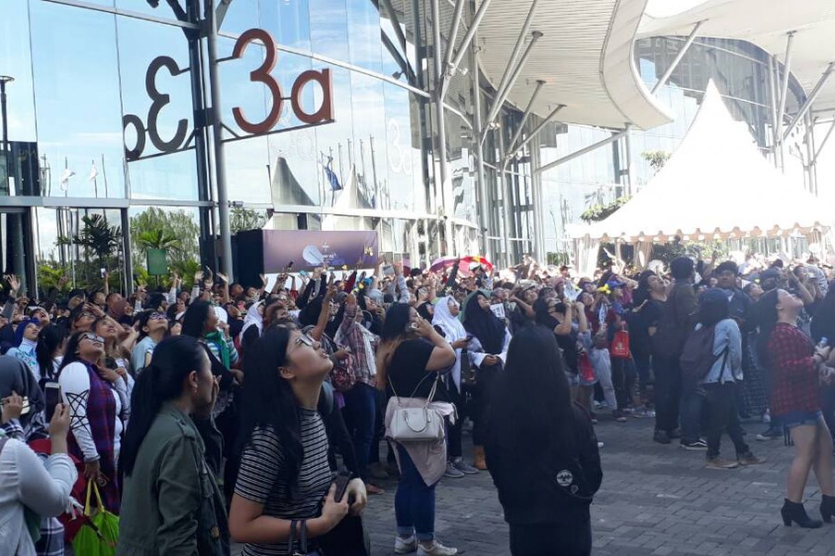 Para A.R.M.Y Indonesia melambaikan tangan ke arah salah satu kamar di Hotel Santika Premiere BSD yang berada di depan venue konser Bangtan Boys dilangsungkan, Indonesia Convention Exhibition (ICE), Tangerang, Sabtu (29/4/2017).