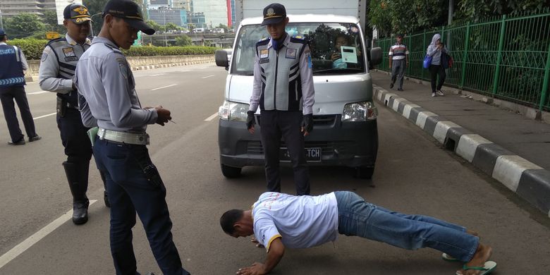 Sopir angkot kena sanksi push up Operasi Keselamatan Jaya 2018 di UKI, Jakarta Timur, Kamis (22/3/2018)