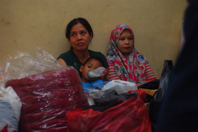 Seorang ibu sedang memberikan susu kepada anaknya di lokasi posko pengungsian sementara korban kebakaran di gedung sekolah SD Empang, Kota Bogor, Selasa (26/12/2017).