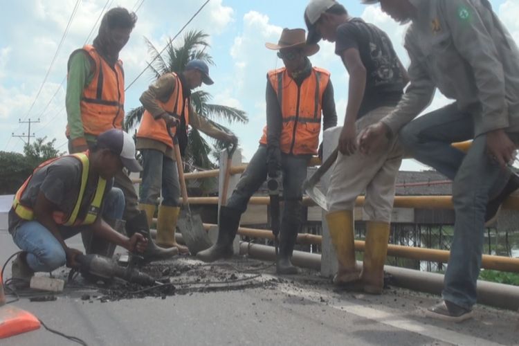 Para pekerja mulai membongkar aspal yang pecah dan rusak di atas jembatan Desa Celika OKI sebelum nantinya ditambal dengan aspal baru. Perbaikan ini untuk meyambuat pemudik dari Pulau Jawa yang hendak menuju Sumatera