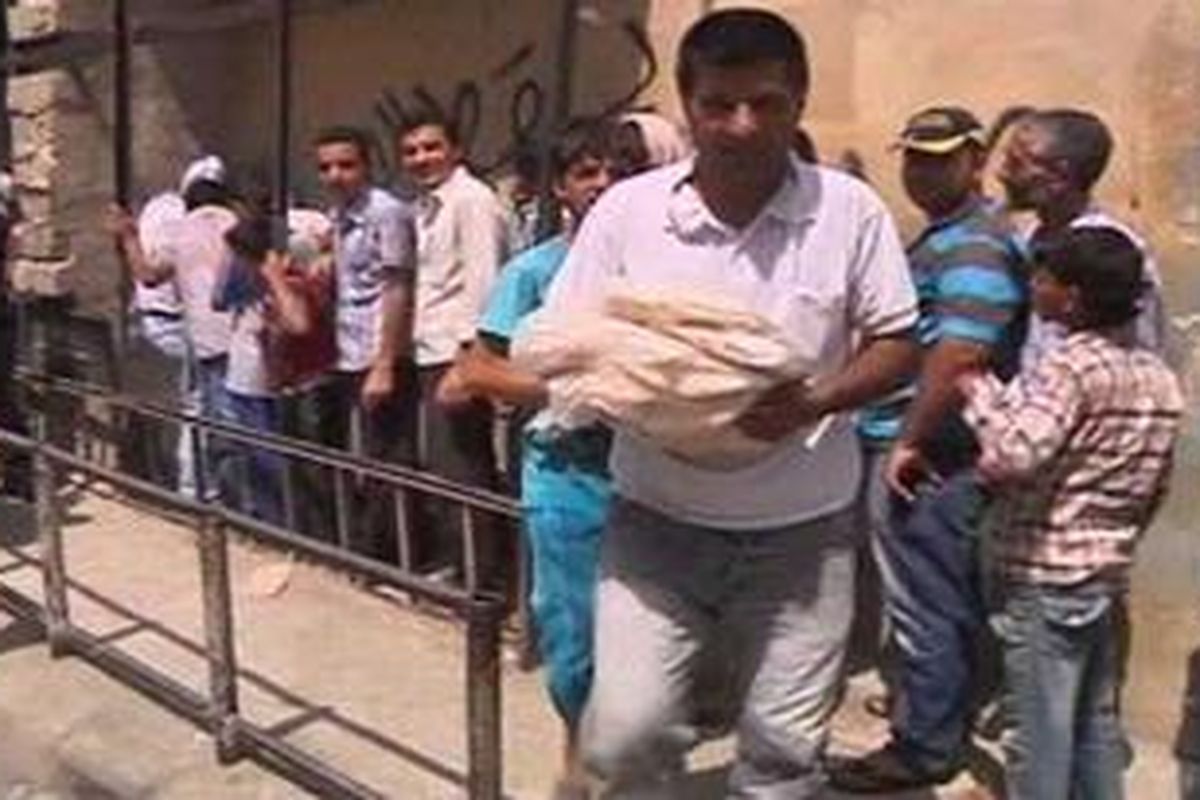 Warga Aleppo yang mengungsi ke fasilitas umum antri pembagian makanan.