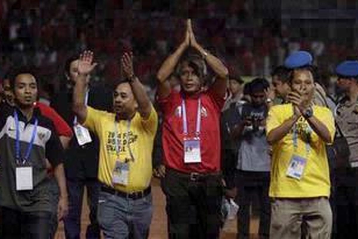 Ketua Umum PSSI Djohar Arifin Husin (dua kanan) dan Sekjen Tri Gustoro (dua kiri) melambaikan tangan untuk menenangkan suporter, dalam laga lanjutan kualifikasi Grup E Piala Dunia 2014 Zona Asia antara Indonesia melawan Bahrain di Stadion Utama Gelora Bung Karno, Senayan Jakarta, Selasa (6/9/2011). Mereka harus turun ke lapangan karena pertandingan sempat dihentikan selama 15 menit karena ulah suporter yang mengarahkan petasan ke beberapa pemain cadangan Bahrain yang sedang melakukan pemanasan.