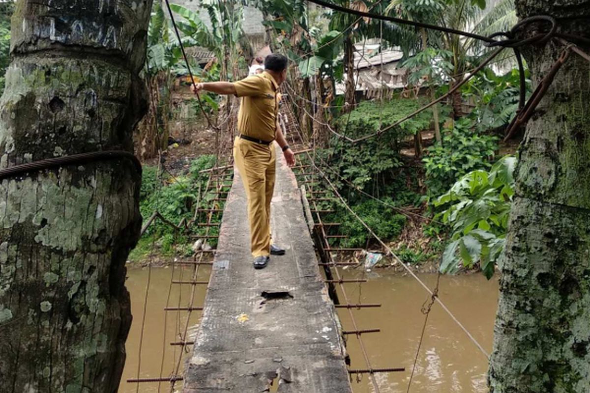 Pegawai Pemprov DKI Jakarta meninjau jembatan gantung di Jalan Gardu, Srengseng Sawah, Jagakarsa, Senin (22/1/2018).