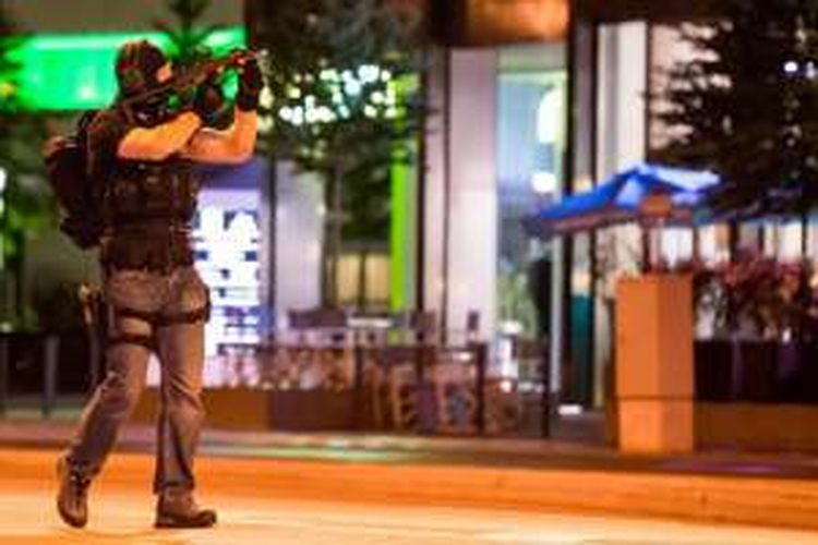 Seorang polisi mengamankan area sekitar pusat perbelanjaan Olympia Einkaufzentrum OEZ di Munich, Jerman, setelah serangan bersenjata yang menewaskan sejumlah orang di tempat itu, Jumat (22/7/2016). 