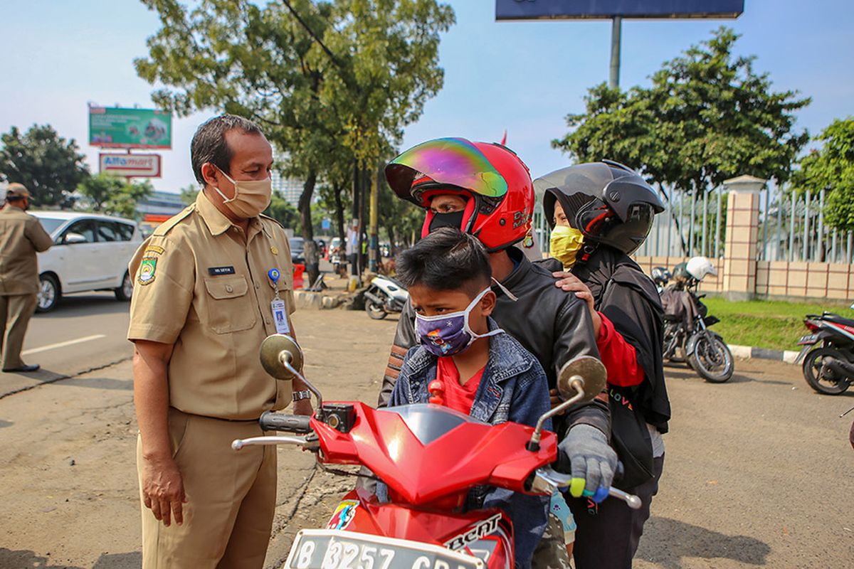 Petugas memeriksa pengendara saat penerapan Pembatasan Sosial Berskala Besar (PSBB) di jalan M.H Thamrin, Cikokol, Kota Tangerang, Banten, Sabtu (18/4/2020). Pemerintah telah resmi menerapkan PSBB di wilayah Tangerang Raya per hari ini dalam rangka percepatan penanganan COVID-19.