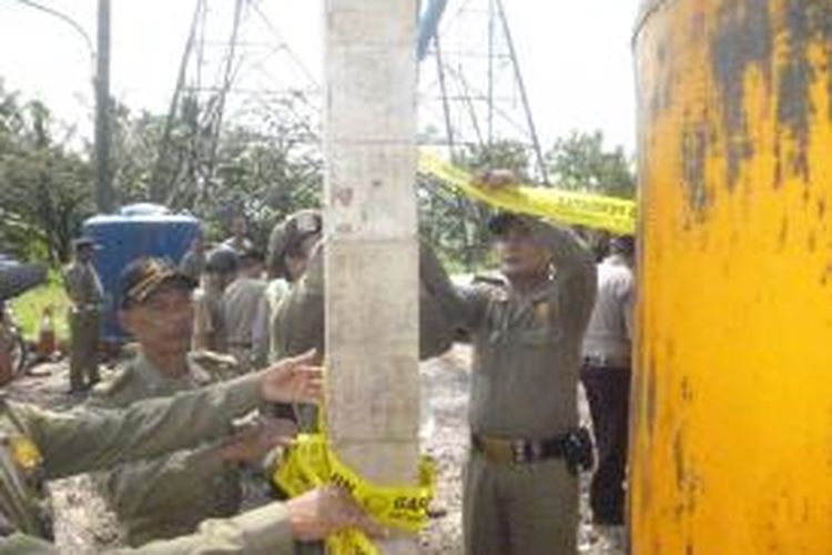 Petugas Satpol PP Kabupaten Semarang, Selasa (15/4/2014) pagi, menyegel depo air ilegal 

yang berada dibawah Saluran Udara Tegangan Ekstra Tinggi (SUTET) di Lingkungan RW III Kelurahan 

Genuk, Ungaran Barat, Kabupaten Semarang.
