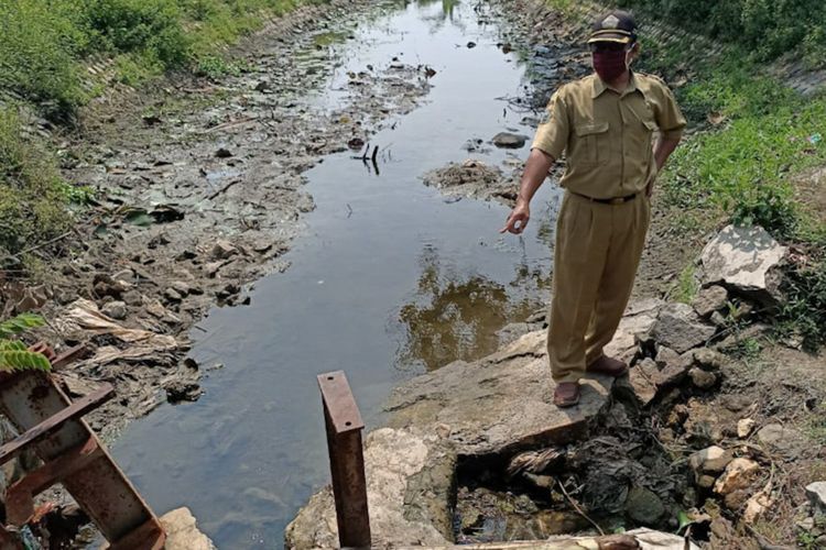 Salah seorang aparat Desa Gredek, saat menunjukkan pintu air di waduk Sumengko yang membutuhkan perbaikan.