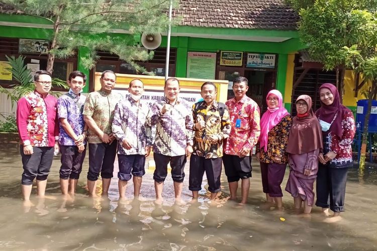 Jajaran Dinas Pendidikan Lamongan, saat mengunjungi salah satu sekolah yang tergenang banjir.