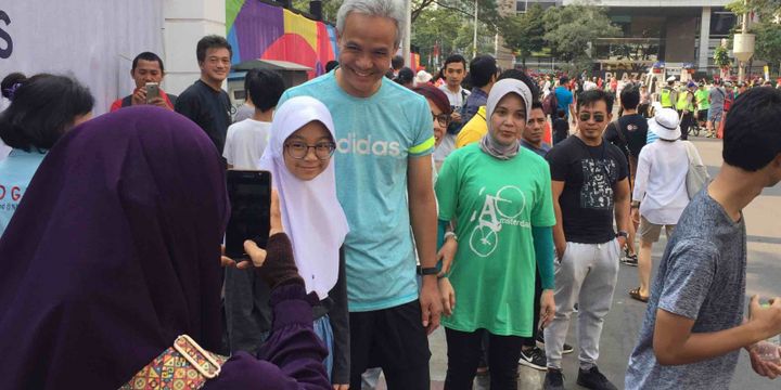 Gubernur terpilih Jawa Tengah Ganjar Pranowo terlihat asyik menonton lomba maraton di Pintu I Gelora Bung Karno, Jakarta Pusat, Sabtu (25/8/2018). Ditemani istrinya, Siti Atiqoh dan anaknya, Muhammad Zinedine Alam Ganjar, ketiganya kompak datang menggunakan setelan pakaian lari.