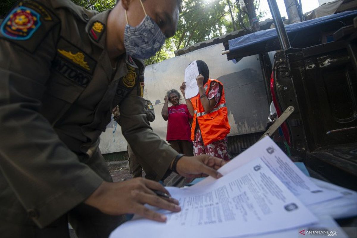 Petugas Satpol PP mendata warga yang melanggar aturan protokol kesehatan COVID-19 selama masa Pembatasan Sosial Berskala Besar (PSBB) transisi di kawasan Juanda, Jakarta, Jumat (21/8/2020). 