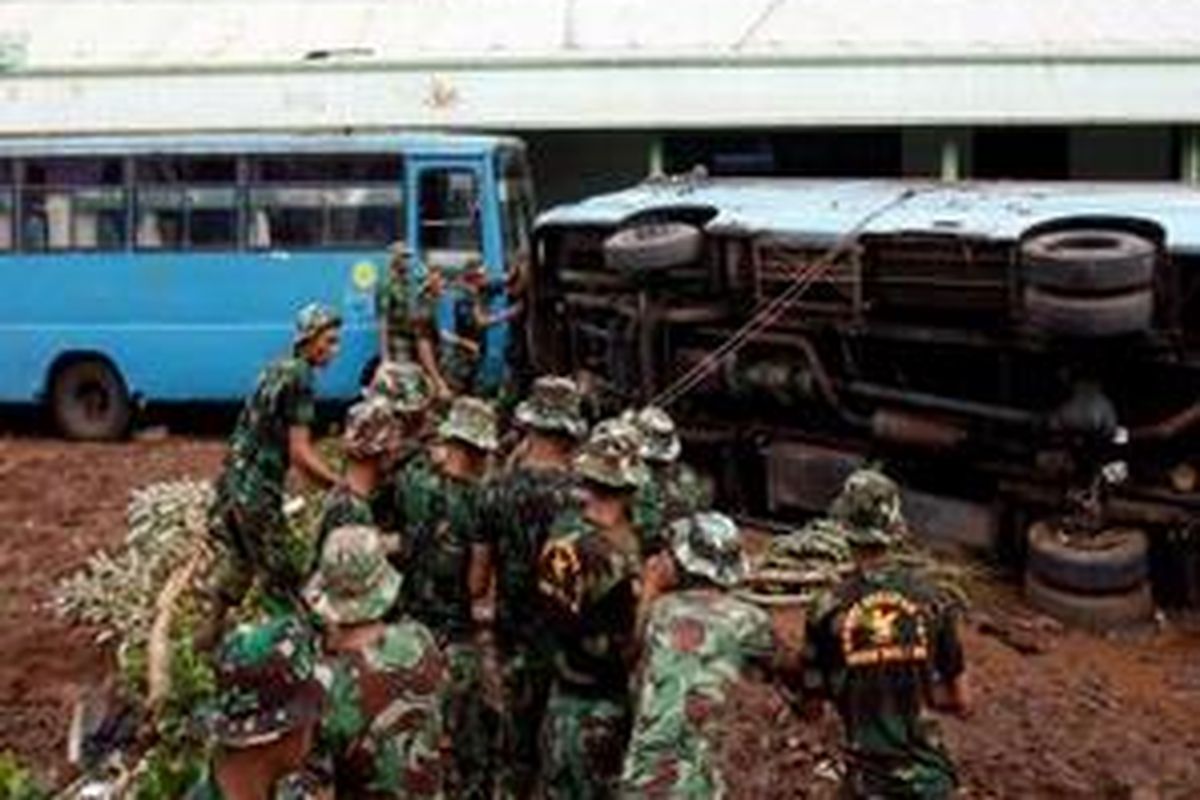 Aparat TNI AD melakukan evakuasi kendaraan milik Universitas Muhammadiyah Jakarta (UMY) yang terbalik di area kampusnya, Ciputat, Tangerang, Banten, Sabtu (28/3). Hingga siang Posko UMJ telah mencatat korban jebolnya tanggul Situ Gintung sebanyak 71 orang meninggal dunia.