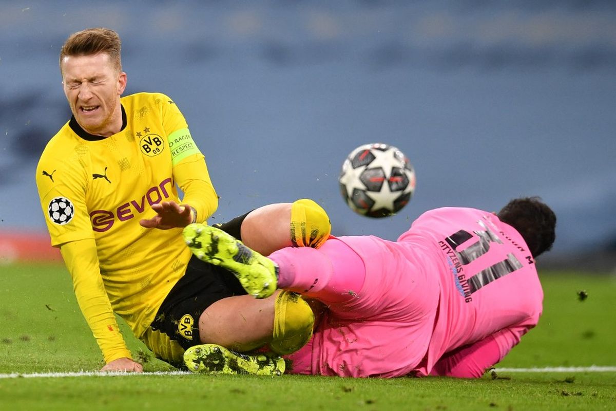 Manchester City menang tipis 2-1 atas Borussia Dortmund pada laga leg pertama babak perempat final Liga Champions, Rabu (7/4/2021) dini hari WIB. Kapten Dortmund Marco Reus dan kiper Man City Ederson berduel dalam foto ini.