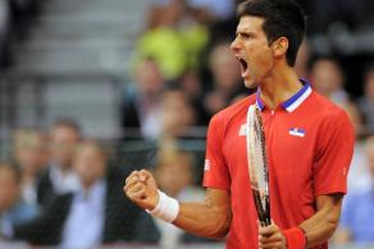 Petenis Serbia, Novak Djokovic, berteriak setelah meraih kemenangan atas Milos Raonic dari Kanada, pada laga keempat semifinal Davis Cup, Minggu (15/9/2013).