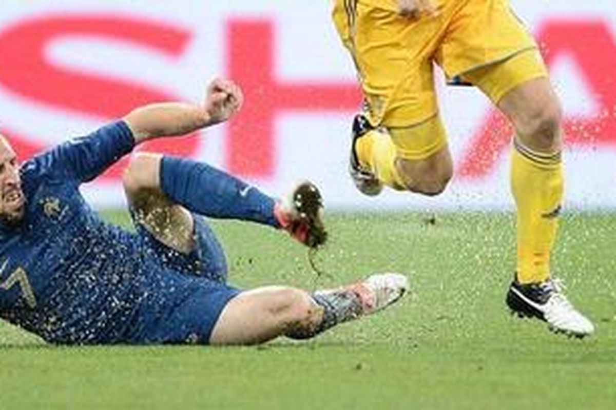 Gelandang Perancis Franck Ribery melalukan sliding tackle terhadap salah satu pemain Ukraina dalam lanjutan pertandingan penyisihan Grup D di Stadion Donbass Arena, Donetsk, Jumat (15/6/2012). 