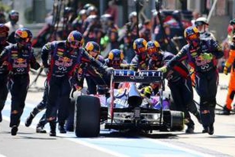 Kru Red Bull menarik mobil Mark Webber kembali ke pit setelah jalan dan kehilangan ban kanan belakang, saat menjalani pit stop pada balapan GP Jerman, Minggu (7/7/2013).