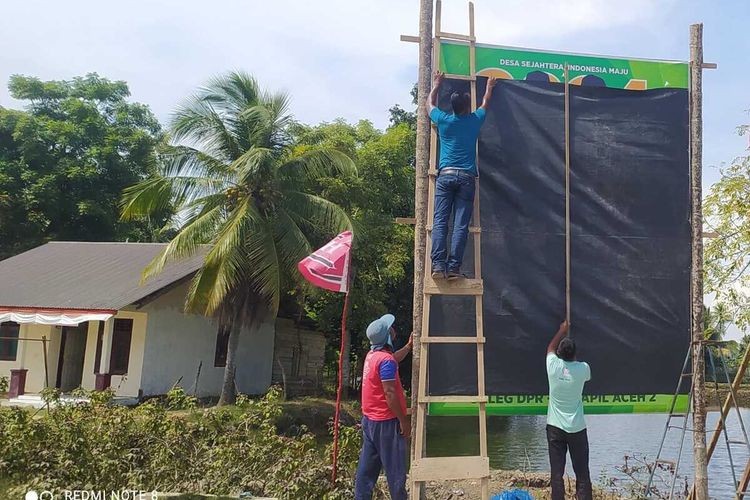 Tim sukses calon anggota legislatif menutup papan kampanye di Desa Lapang, Kecamatan Lapang, Kabupaten Aceh Utara, Senin (7/11/2023)