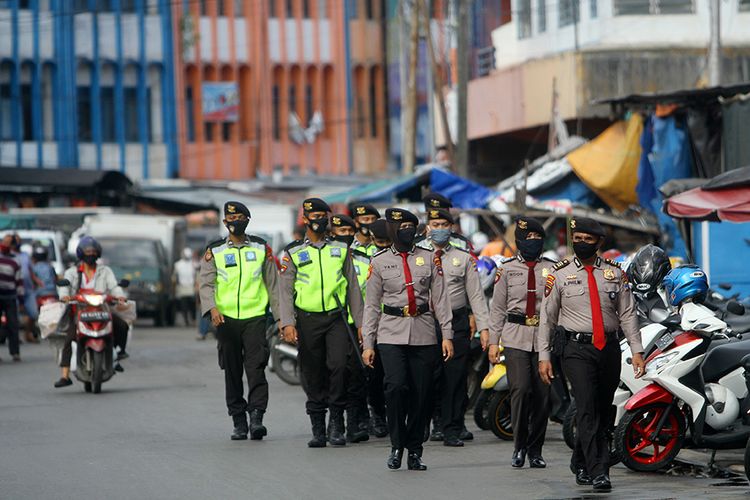 Polisi melakukan patroli penegakan aturan Pembatasan Sosial Berskala Besar (PSBB) di kawasan Pasar Baru Banjarmasin, Kalimantan Selatan, Senin (27/4/2020). Kegiatan tersebut sebagai upaya Polri untuk mendukung aturan pemerintah saat PSBB di Kota Banjarmasin serta memberikan edukasi tentang penanganan dan pencegahan penyebaran COVID-19 di tempat keramaian.