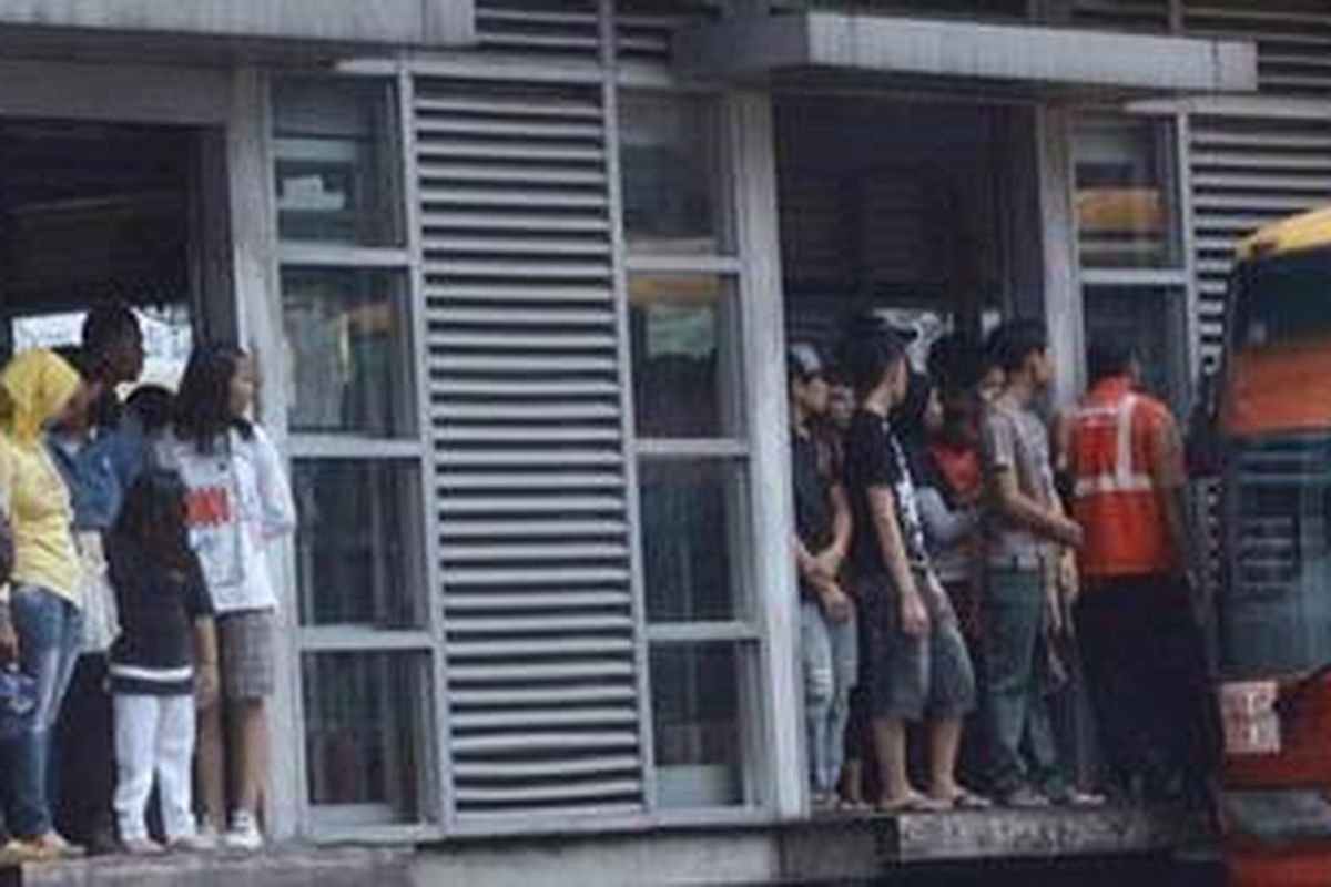 Warga antre saat menunggu kedatangan armada bus transjakarta di Halte Busway Harmoni, Jakarta Pusat, Minggu (4/11/2012).  