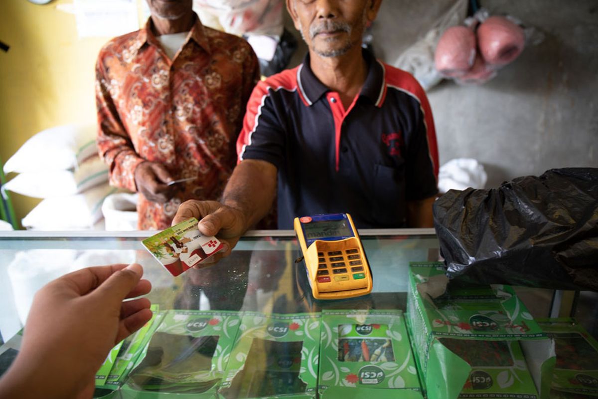 Petani menebus pupuk bersubsidi di kios resmi menggunakan kartu tani