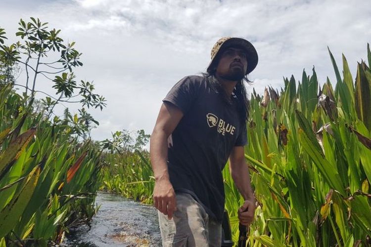 Mustafa, 33 tahun, mengemudikan perahu menyusuri sungai di Rawa Singkil.