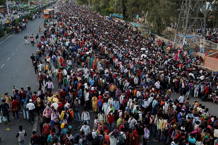 Pekerja migran memadati terminal bus untuk kembali ke kampung halaman mereka saat diberlakukan lockdown 21 hari secara nasional untuk menekan penyebaran virus corona (COVID-19), di Ghaziabad, pinggiran New Delhi, India, Sabtu (28/3/2020).