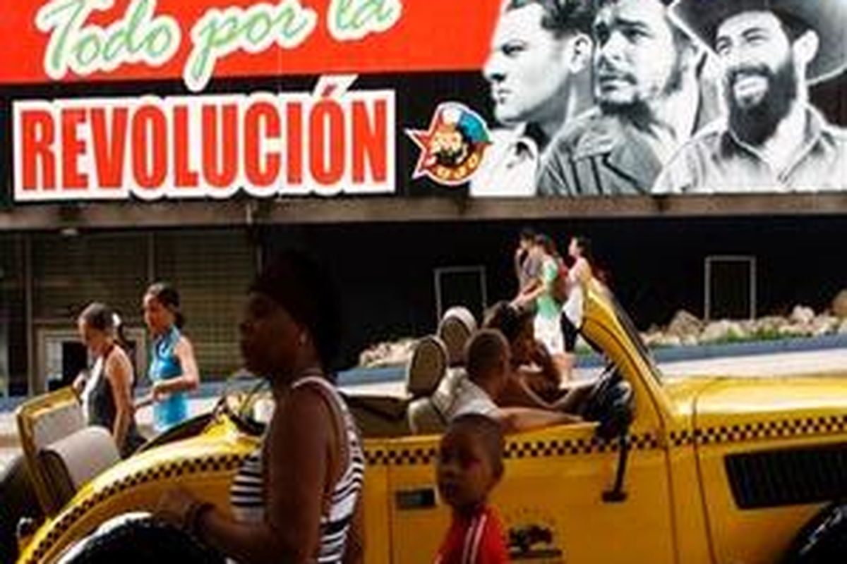 People walk past a billboard taht reads in Spanish Everything for the Revolution, with images of revolutionary leaders, from left, Julio Antonio Mella, Ernesto Che Guevara and Camilo Cienfuegos in Havana, Sunday, July 25, 2010. The Cuban government has said nothing about whether Cubas former leader Fidel Castro will be on hand for the main celebration that will mark the 57th anniversary of the July 26, 1953, when the Castros led an attack on the Moncada army barracks in the eastern city of Santiago and a smaller military outpost in the nearby city of Bayamo. The operation failed but Cubans consider it the beginning of the revolution that culminated with dictator Fulgencio Batistas ouster on New Years Day 1959. 