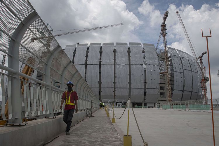 Pekerja berjalan di lokasi pembangunan Jakarta International Stadium (JIS), Tanjung Priok, Jakarta, Selasa (16/11/2021). Pembangunan stadion berkapasitas 82.000 penonton yang ditargetkan selesai pada akhir 2021 itu  berdasarkan data per 15 November 2021 telah mencapai 83,22 persen.
