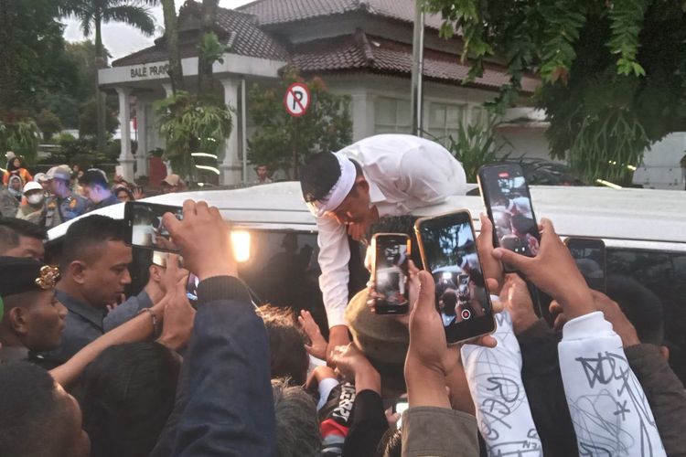 GUbernur Jawa Barat, Dedi Mulyadi berdialog dengan warga Cianjur dari atas sunroof mobilnya sebelum meninggalkan Pendopo Bupati Cianjur, usai menghadiri peluncuran program Cianjur Nyaah ka Indung, Jumat (11/4/2025).