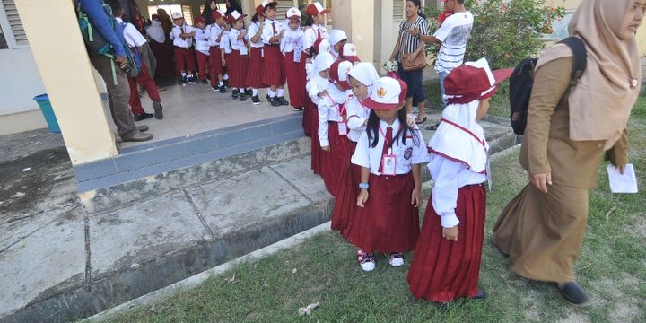 Sejumlah siswa dan siswi peserta didik baru diajak berkeliling untuk mengenal lingkungan pada hari pertama masuk sekolah di SDN Madani, Palu, Sulawesi Tengah, Senin (9/7). Seluruh siswa SD, SMP, SMA/SMK dan sederajatnya setempat mulai masuk kembali bersekolah pada tahun ajaran baru 2018/2019. 