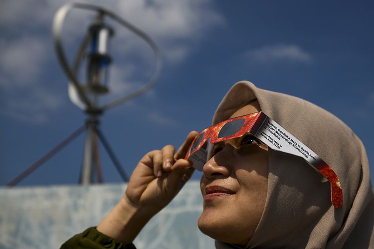 Warga menggunakan kacamata khusus saat mengamati proses gerhana matahari cincin di Banda Aceh, Aceh, Kamis (26/12/2019). Menurut daftar yang dirilis BMKG, fenomena astronomi gerhana matahari cincin akan melewati 25 kota/kabupaten di Indonesia pada Kamis hari ini.