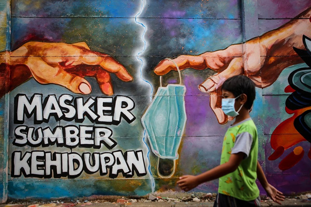 Seorang bocah melintas di depan mural tentang penggunaan masker di Kota Tangerang, Banten, Minggu (21/12/2020). Mural tersebut dibuat sebagai edukasi kepada masyarakat untuk selalu menggunakan masker guna mencegah penyebaran COVID-19. ANTARA FOTO/Fauzan/aww.