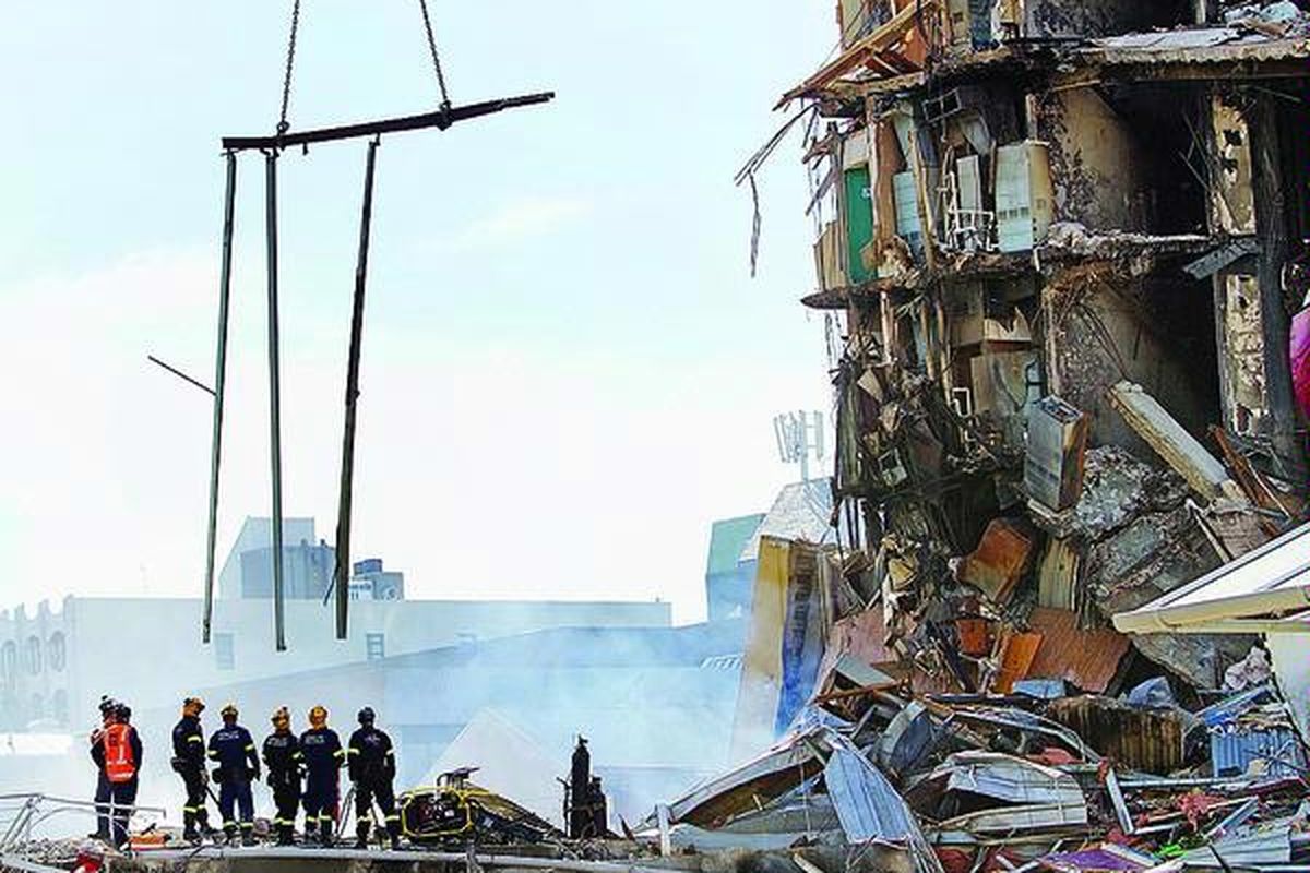 Anggota tim penyelamat berdiri di reruntuhan berasap gedung CTV yang diduga menjadi tempat terkuburnya 48 mahasiswa dan anggota staf CTV, termasuk sejumlah pelajar Asia, di Christchurch, Kamis (24/2). Gempa berkekuatan 6,3 skala Richter yang terjadi dua hari sebelumnya dan meluluhlantakkan sebagian kota Christchurch menelan korban setidaknya 76 jiwa tewas.