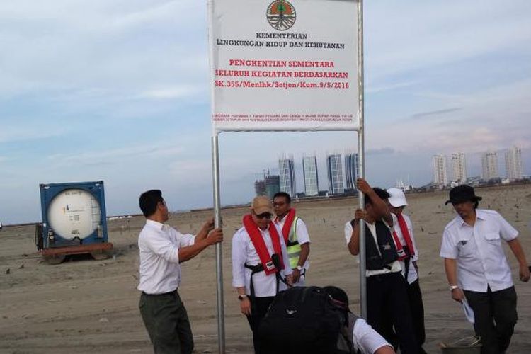 Sejumlah petugas dari Kementerian Lingkungan Hidup dan Kehutanan saat memasang plang penghentian proyek reklamasi di Pulau G pada Rabu (11/5/2016).
