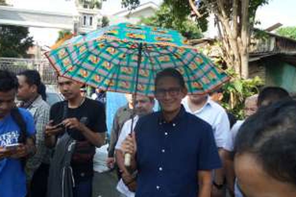 Calon wakil gubernur DKI Jakarta nomor pemilihan tiga, Sandiaga Uno, berpose dengan payung hasil kreasi warga RW 03 Kelurahan Malaka Sari, Kecamatan Duren Sawit, Jakarta Timur, Senin (7/11/2016). Payung tersebut dibuat dari sampah hasil daur ulang warga setempat.