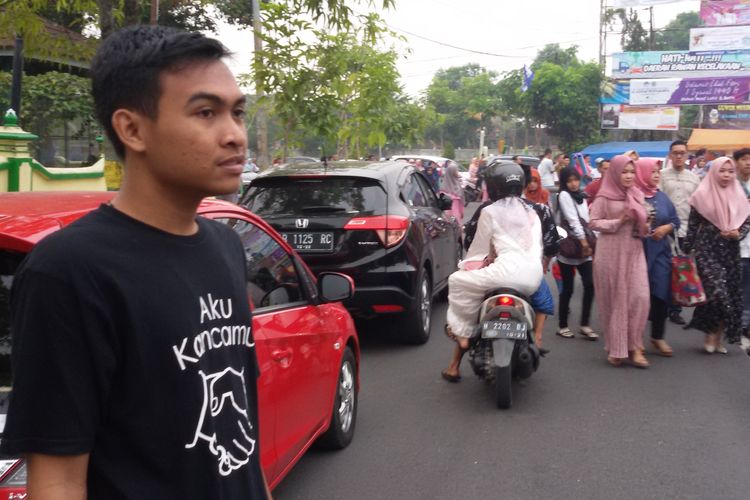 Beberapa kelompok pemuda gereja membantu kelancaran dan ketertiban kendaraan parkir selagi berlangsung Shalat Id di alun-alun Wates. Salah satu kelompok mengenakan kaos bertulis Aku Kancamu yang berarti aku temanmu. 